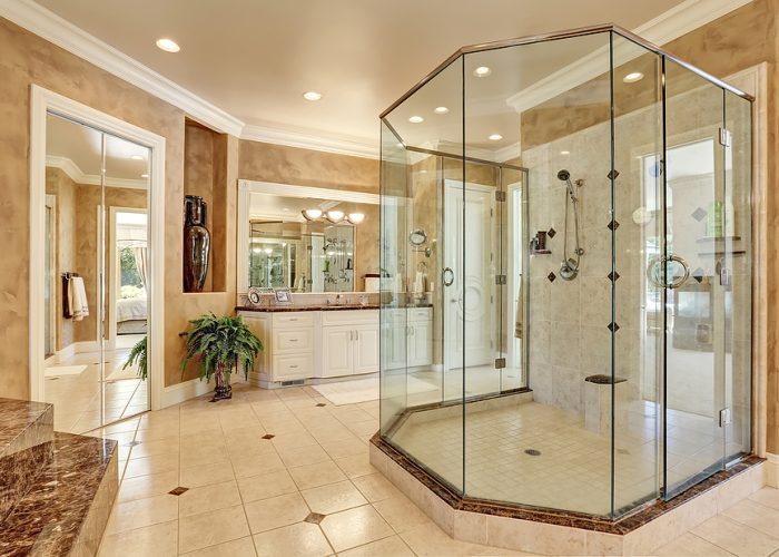 Beautiful luxury marble bathroom interior in beige color. Large glass walk in shower. Northwest USA